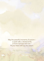 Inside of a watercolor Thanksgiving card with a serene autumn background, displaying the heartfelt message: "May the peaceful moments of autumn – a quiet walk, a shared smile, a home warmed with love – fill your heart with joy this season."
