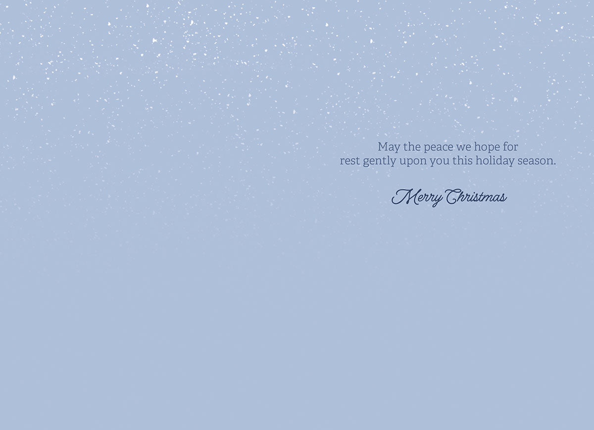 Interior of a holiday greeting card with a light blue background and a heartfelt message wishing peace for the recipient during the season.