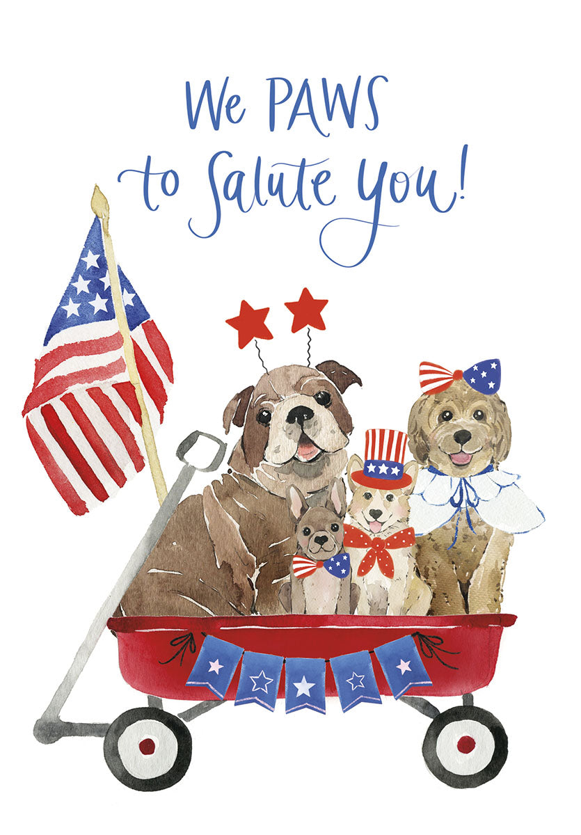 Cute watercolor illustration of four dogs in a red wagon decorated with an American flag and patriotic stars, with text 'We PAWS to salute you!' greeting card front for a child's special day.