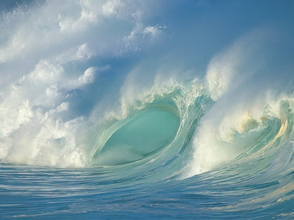 Spectacular blue ocean wave curling with white foam against a cloudy sky, showcasing the power and beauty of the sea.