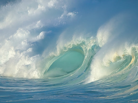 Spectacular blue ocean wave curling with white foam against a cloudy sky, showcasing the power and beauty of the sea.