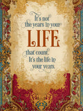 Front of an elegant, vintage-style greeting card with ornate gold, red, and blue borders. The central message in stylish fonts reads: "It's not the years in your LIFE that count. It's the life in your years." on a textured cream background.