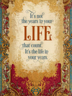 Front of an elegant, vintage-style greeting card with ornate gold, red, and blue borders. The central message in stylish fonts reads: "It's not the years in your LIFE that count. It's the life in your years." on a textured cream background.