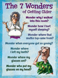 Humorous greeting card depicting 'The 7 Wonders of Getting Older' with cartoon illustrations of a confused elderly woman shrugging and an elderly man scratching his head, listing funny age-related forgetfulness and common senior moments.