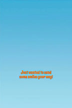 Inside of a greeting card with a light blue background and warm orange text reading 'Just wanted to send some smiles your way!', conveying a cheerful message.