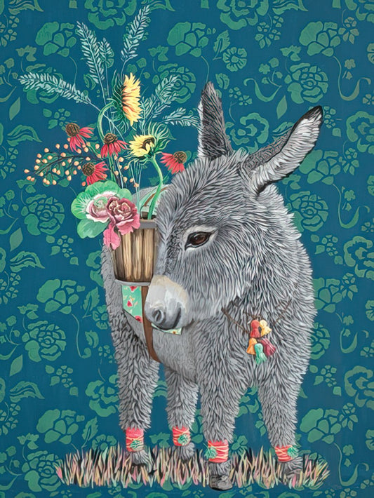Fluffy gray donkey with a floral basket on its back, adorned with colorful leg wraps, standing against a dark teal botanical patterned background.