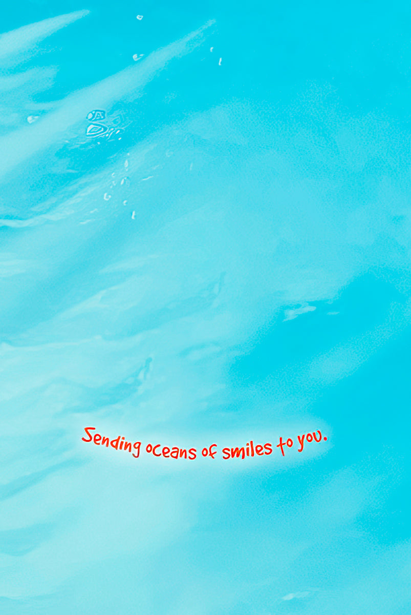 Inside of a greeting card with a light blue background and red text that reads 'Sending oceans of smiles to you.'.