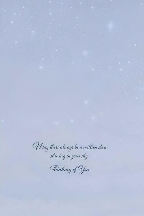 The inside of a light blue greeting card with subtle star-like flecks, featuring elegant script text that reads: 'May there always be a million stars shining in your sky. Thinking of You.'