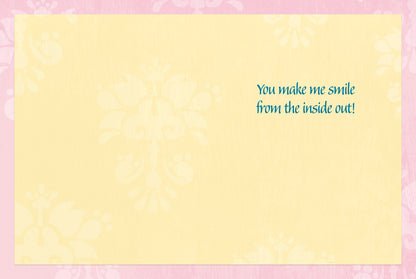 Inside of greeting card with a light yellow background, pink border, and text that reads 'You make me smile from the inside out!'