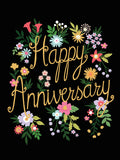 Elegant floral anniversary card with 'Happy Anniversary' script on a black background, perfect for a wife or partner, featuring vibrant wildflowers and green foliage.