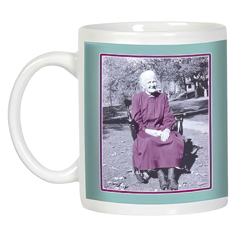 White ceramic mug, side view, showcasing a black and white photo of an elegant elderly woman sitting outdoors, framed in teal and purple, ideal for unique gifts.