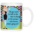 Front view of a white ceramic coffee mug with a sassy blonde woman cartoon illustration in a black dress, holding coffee and a folder. Features the quote: 'Do you want to talk to the man in charge or the woman who knows what's going on?' on a blue oval, with a retro colorful geometric background.