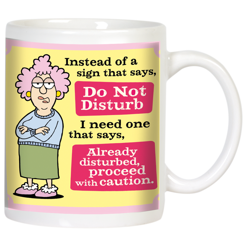 Sassy white ceramic mug featuring a cartoon of a grumpy woman with pink hair and glasses, arms crossed. Text reads: 'Instead of a sign that says, Do Not Disturb I need one that says, Already disturbed, proceed with caution.' Perfect funny gift.
