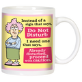 Sassy white ceramic mug featuring a cartoon of a grumpy woman with pink hair and glasses, arms crossed. Text reads: 'Instead of a sign that says, Do Not Disturb I need one that says, Already disturbed, proceed with caution.' Perfect funny gift.