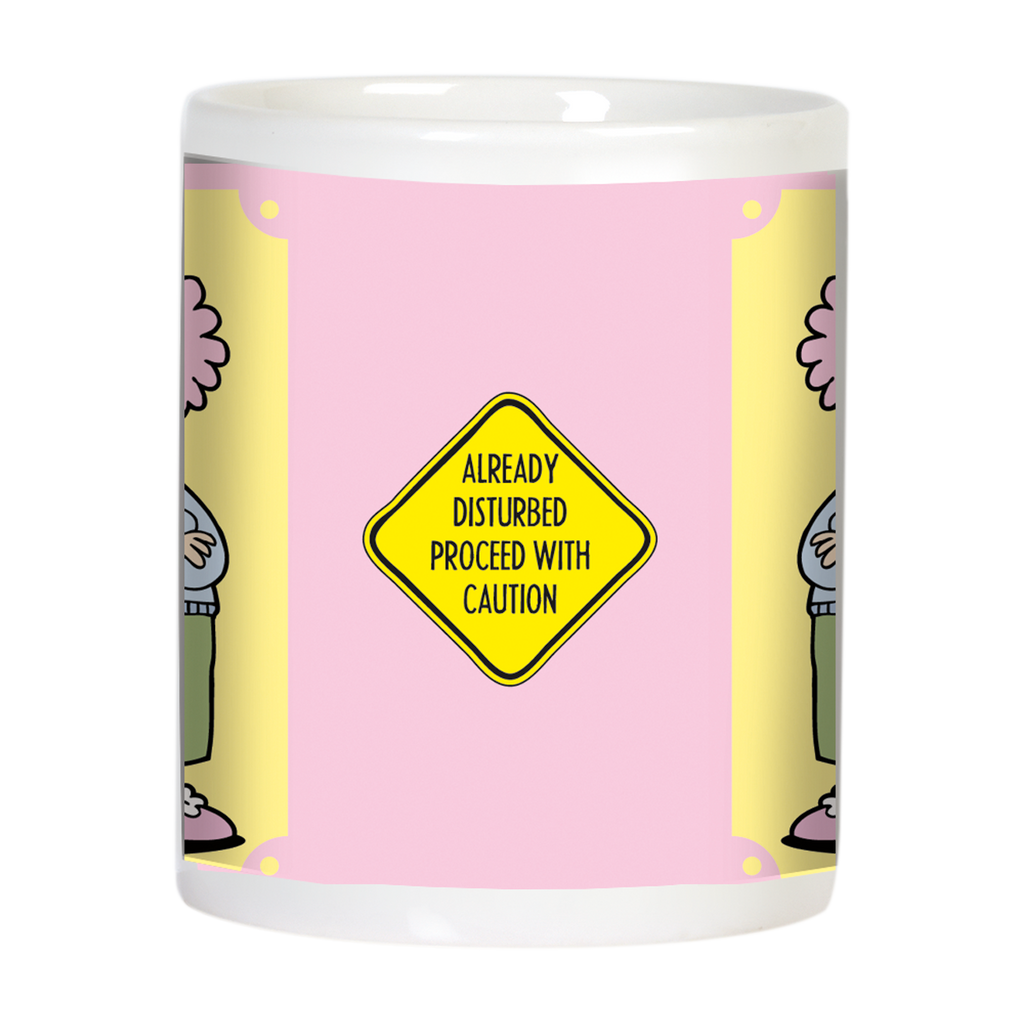 Back view of the funny ceramic mug, showcasing a yellow diamond caution sign with black text: 'ALREADY DISTURBED PROCEED WITH CAUTION' on a pink and yellow background.