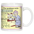 Front view of a funny white ceramic coffee mug featuring a confused woman in a robe struggling to make coffee before her first sip, with the humorous text 'The problem with COFFEE is trying to make it when you haven't had any yet.' Perfect for coffee lovers.