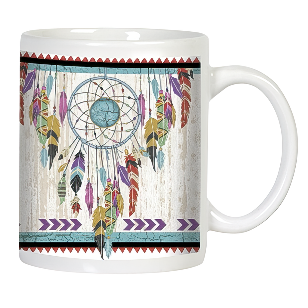Front view of a white ceramic mug featuring a vibrant, multi-colored dreamcatcher design with various feathers and a prominent turquoise stone, set against a distressed white wood-grain background, bordered by red and teal geometric patterns.
