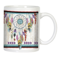 Front view of a white ceramic mug featuring a vibrant, multi-colored dreamcatcher design with various feathers and a prominent turquoise stone, set against a distressed white wood-grain background, bordered by red and teal geometric patterns.