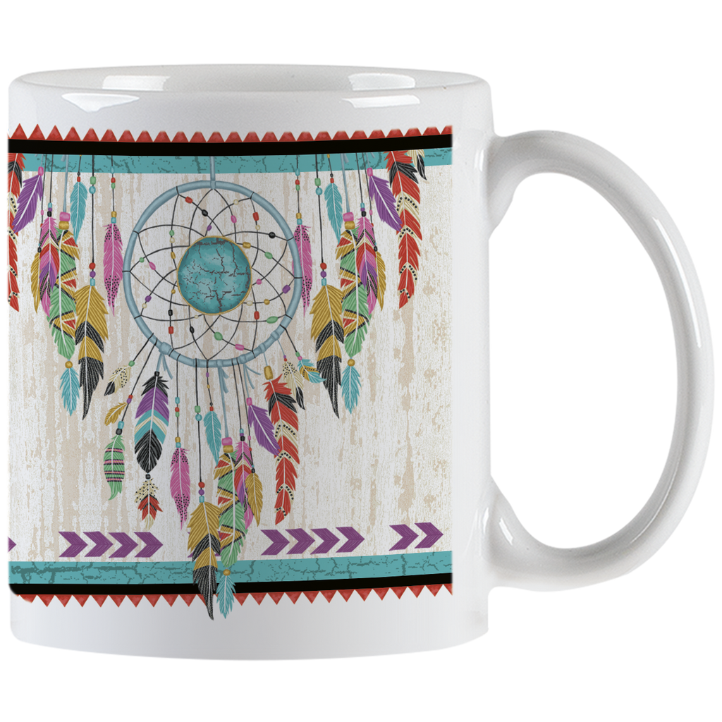 White ceramic mug featuring a vibrant Native American inspired dreamcatcher design with colorful feathers and an artisan turquoise center, handle visible.