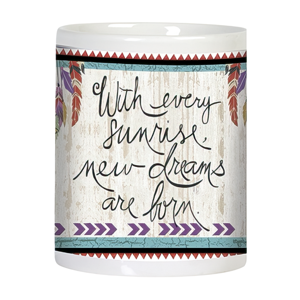 Side view of a white ceramic mug showcasing the inspirational quote 'With every sunrise new dreams are born' in elegant script font, flanked by colorful feathers, all against a textured white wood-grain background with tribal borders.