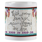 Inspirational white ceramic mug with the quote "With every sunrise, new dreams are born." in elegant script on a rustic wood-grain background with feather details.