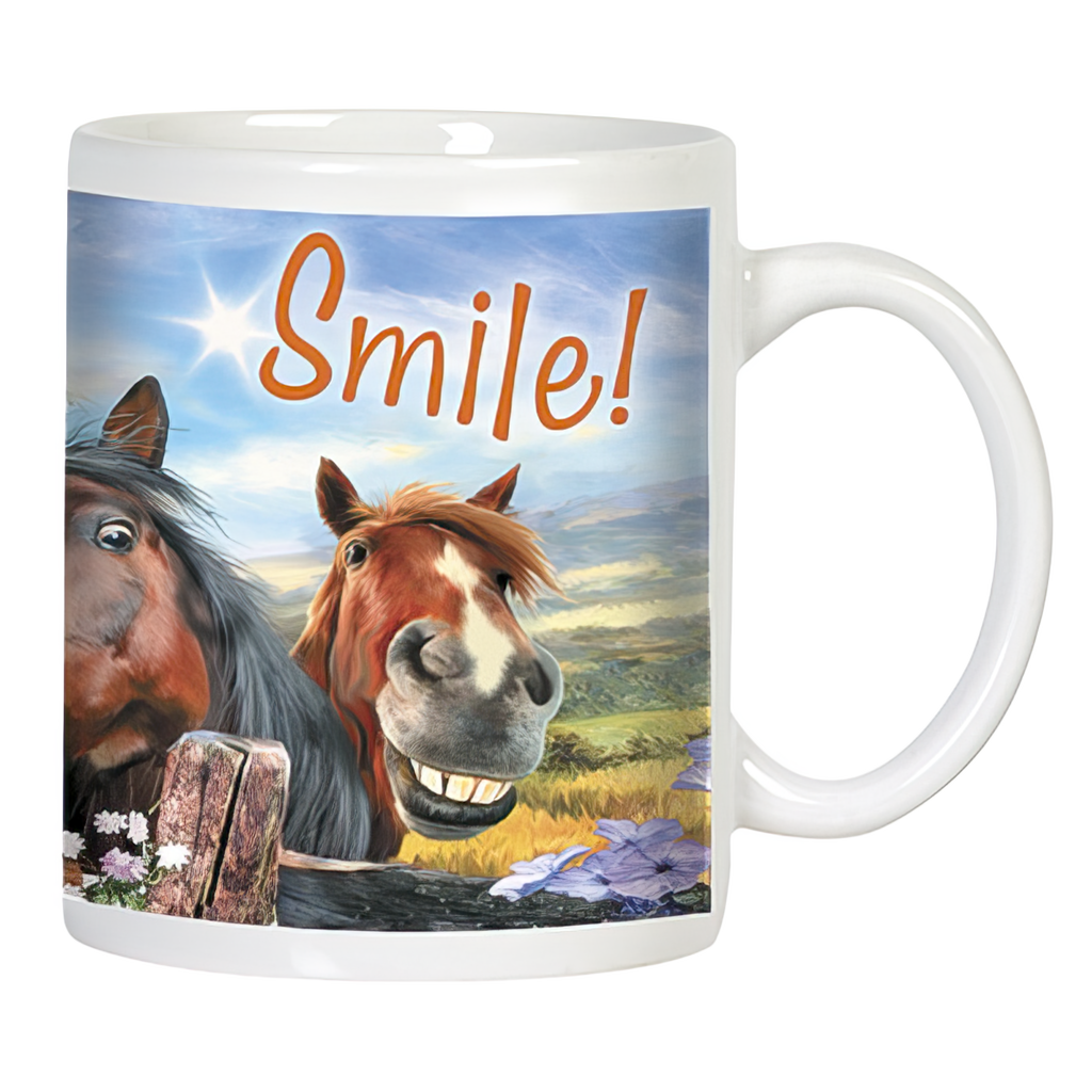 Close-up of a white ceramic mug featuring a smiling brown horse and a dark horse peeking from behind a wooden fence, with "Smile!" text and a sunny landscape background.
