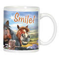 Close-up of a white ceramic mug featuring a smiling brown horse and a dark horse peeking from behind a wooden fence, with "Smile!" text and a sunny landscape background.