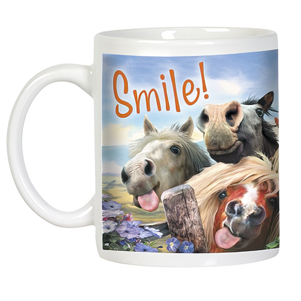 White ceramic mug featuring a wraparound funny horse design. Three cartoon horses are depicted with amusing faces, including one with buck teeth and a wide smile, and two with tongues playfully sticking out. The word "Smile!" is written in orange script above them, against a bright sky and green field background.