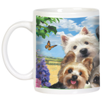 Close-up of a white dog-themed mug displaying a Westie, Yorkshire Terrier, and Pug smiling, with purple flowers and a butterfly in a sunny field backdrop.