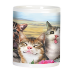 Close-up of a white mug depicting three cute kittens with varied expressions, including a smiling one and one with its tongue out, amidst colorful flowers.