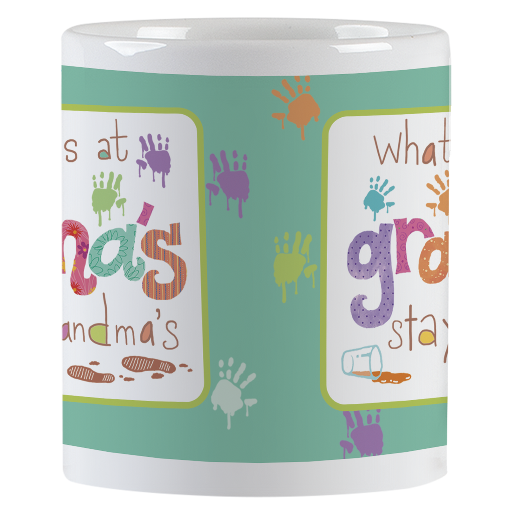 Close-up side view of a white ceramic mug, showing colorful 'grandma's stays at grandma's' text with various colored handprints and paint drops, ideal for a grandparent's humorous coffee cup.