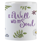 Front view of the 'It is Well with my Soul' coffee mug, showcasing the elegant purple script surrounded by detailed watercolor birds, daisies, and delicate foliage, perfect for daily encouragement.