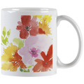 White ceramic mug with vibrant watercolor floral design featuring red, pink, yellow, and orange blossoms, with a white handle visible on the right.