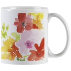 White ceramic mug with vibrant watercolor floral design featuring red, pink, yellow, and orange blossoms, with a white handle visible on the right.