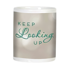Side view of an inspirational white ceramic mug displaying 'KEEP Looking UP' in elegant green script on a subtle, bokeh-effect light grey background.