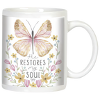 White ceramic coffee mug with watercolor butterfly and floral design. Features inspirational quote 'He RESTORES my SOUL Psalm 23:3' in elegant typography, perfect for spiritual comfort.
