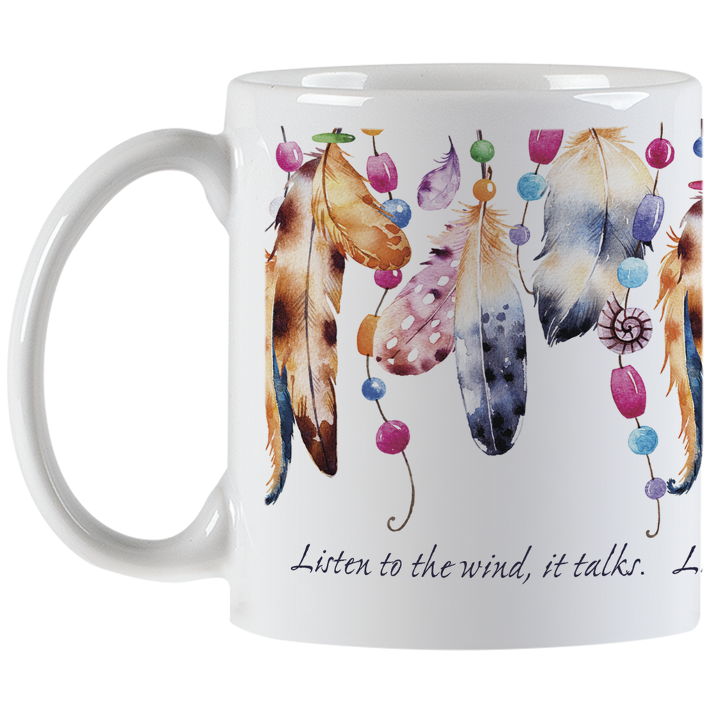 White ceramic coffee mug viewed from the left side with its handle. The mug is adorned with an intricate pattern of watercolor feathers and bright beads, suggesting a spiritual or bohemian theme. The inspirational message 'Listen to the wind, it talks.' is elegantly scripted on the mug's lower portion.