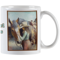 Close-up of a white ceramic mug featuring an artistic painting of a cowgirl in a hat gently touching a horse's head, framed by a rustic border. Ideal for horse lovers.