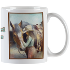 Close-up of a white ceramic mug featuring an artistic painting of a cowgirl in a hat gently touching a horse's head, framed by a rustic border. Ideal for horse lovers.