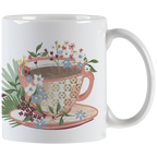 White ceramic mug featuring an elegant floral teacup design overflowing with colorful blossoms, perfect for morning coffee or tea.