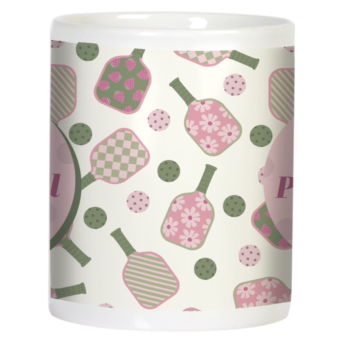 Side view of white ceramic pickleball mug, showcasing the continuous pink and green pattern of paddles and balls with polka dots, wrapped around the mug body.