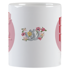 Side view of a white ceramic mug, showcasing a vibrant design of grey horseshoes surrounded by an array of pink, yellow, and white flowers, set against a subtle pink background.