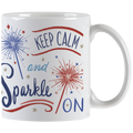 White ceramic mug with 'Keep Calm and Sparkle ON' typography and red and blue sparkler illustrations, showing the handle.