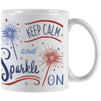 White ceramic mug with 'Keep Calm and Sparkle ON' typography and red and blue sparkler illustrations, showing the handle.