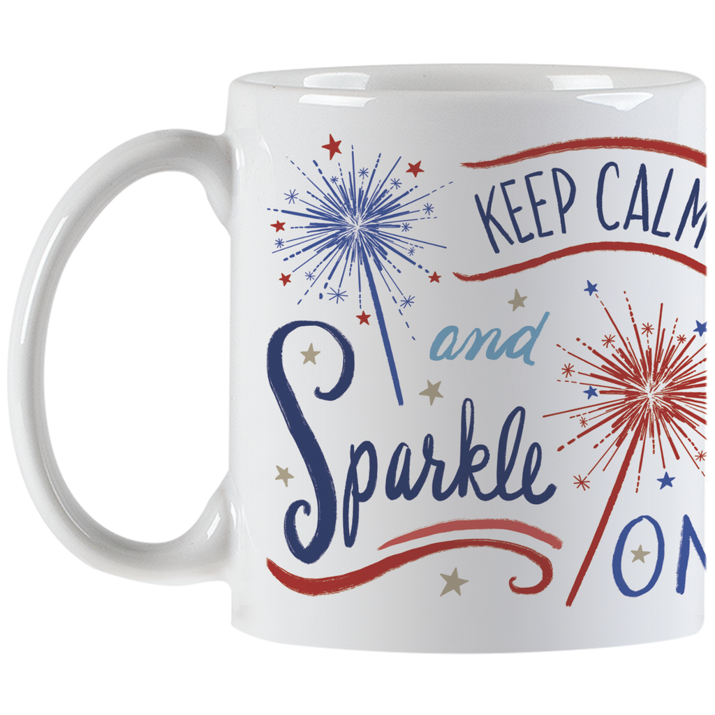 Full view of a white ceramic coffee mug with an encouraging 'Keep Calm and Sparkle ON' message, decorative red and blue sparklers, and stars, with the handle visible.