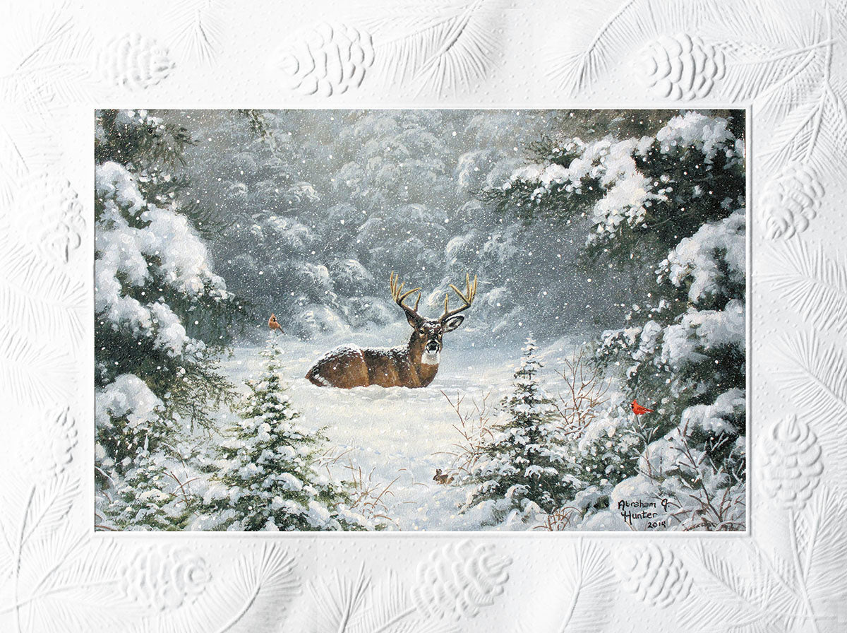 A majestic whitetail buck bedded down in a snow-covered evergreen forest, with light snowfall and two small red birds nearby.