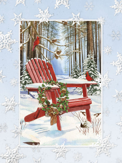 Red Adirondack chair in snow with holiday wreath, pinecones, cardinals, and snowy forest backdrop.