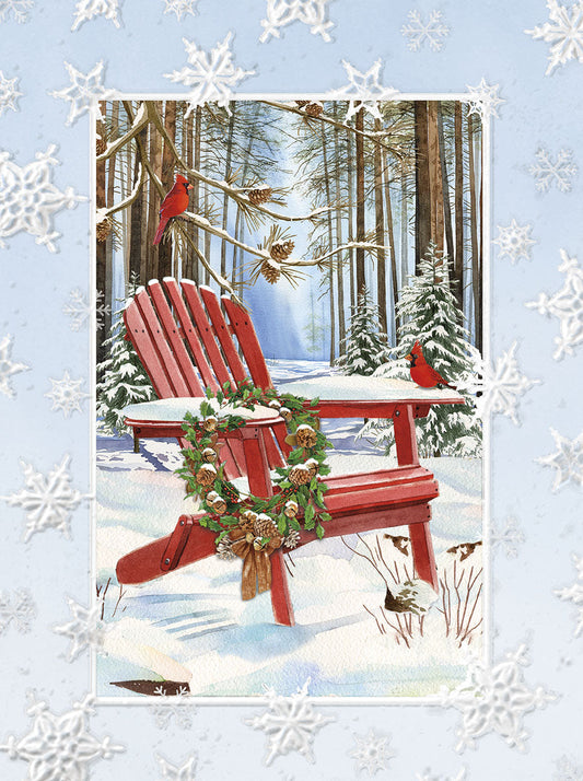 Red Adirondack chair in snow with holiday wreath, pinecones, cardinals, and snowy forest backdrop.