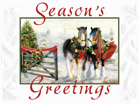 Front of a festive greeting card showing two decorated draft horses pulling a sled in a snowy landscape with a Christmas tree and 'Season's Greetings'.