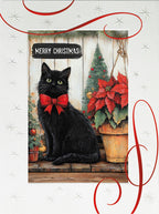 Festive black cat wearing a red bow tie in a rustic setting with poinsettias, mini pine trees, and a 'MERRY CHRISTMAS' sign. Front of a holiday greeting card.
